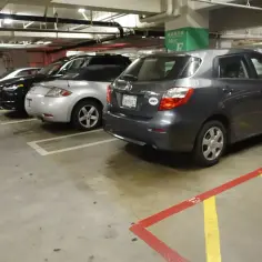 Wspólnota mieszkaniowa: opłaty za garaż. Samochody zaparkowane na podziemnym parkingu, w tym ciemnoszary hatchback.