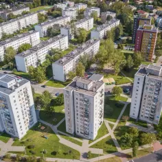 Widok z lotu ptaka na osiedle z blokami mieszkalnymi i drzewami.