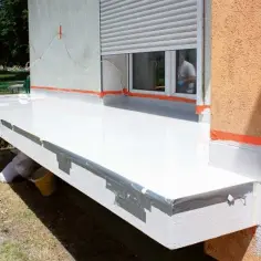 Balkon w trakcie budowy, biała membrana hydroizolacyjna, pomarańczowa taśma uszczelniająca. Jak zrobić balkon krok po kroku.