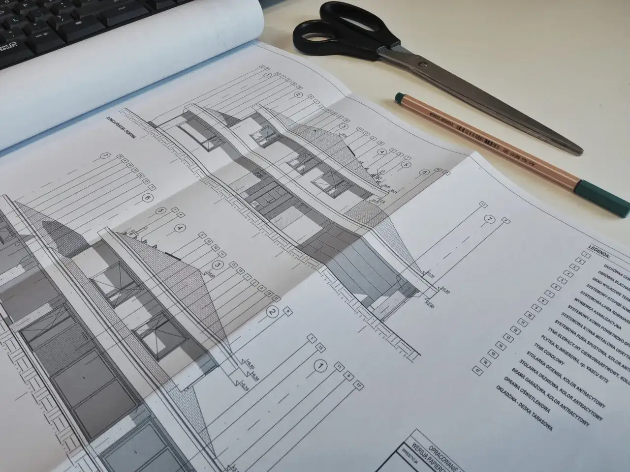 Projekt architektoniczno budowlany zawiera szczegółowe rysunki i legendę, pokazujące elementy konstrukcyjne i wykończeniowe budynku.