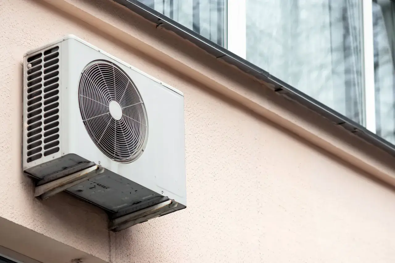 Klimatyzator zamontowany na ścianie budynku, co może być ingerencją w części wspólne nieruchomości.