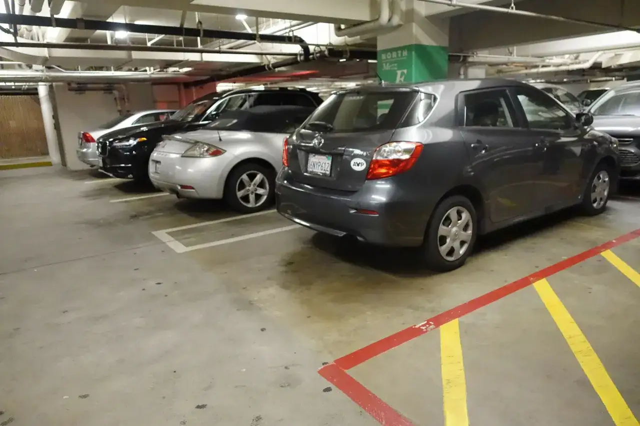 Wspólnota mieszkaniowa: opłaty za garaż. Samochody zaparkowane na podziemnym parkingu.